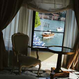View through the window of the Dogaressa Suite onto the canal where two water taxis make their way round the pali da casada.