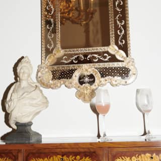 Two half-drunk champagne glasses of the Cipriani’s famed Bellinis are left on a sideboard next to a marble bust of a goddess