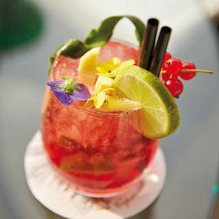 Buonanotte cocktail garnished with flowers lime and berries