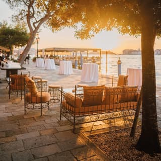 The setting sun casts a path of gold across the canal behind the Cip’s Club deck. Soft sofas offer extra seating waterside