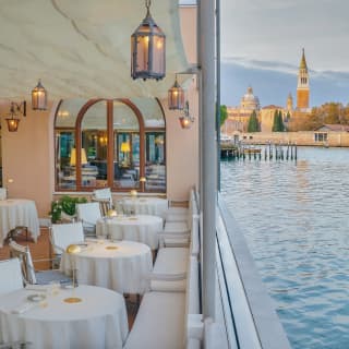 Elegant lantern lit outdoor restaurant with circular linen coated tables