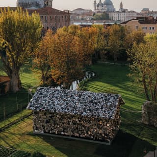 Artist Subodh Gupta's MITICO exhibit - a hut of pots and pans - is installed in Cipriani's gardens, seen from above.