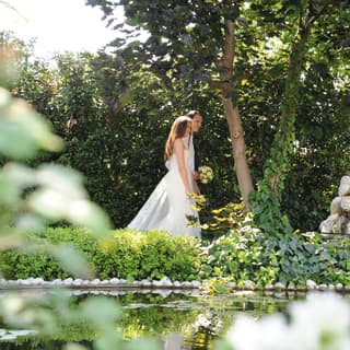 Bride and groom strolling through the Casanova gardens of Hotel Cipriani