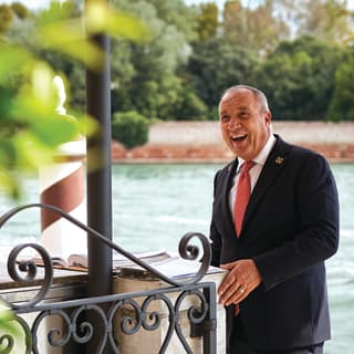 Concierge, Roberto Senigaglia, smiles warmly as he greets a guest (not pictured) at the waterside entrance to the Hotel
