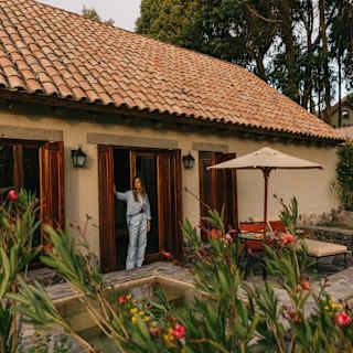 A woman standing in the window frame of her casita