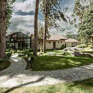 A left turn in a forked garden path leads to Samay Spa, located in a greenhouse-like structure between traditional buildings.