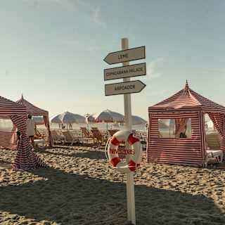 A life ring hangs on a signpost with directions to Leme, Copacabana Palace and Arpoador, seen on a beach with red cabanas.
