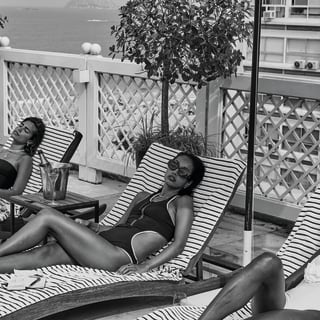 Black and white shot of a group of women relaxing on lounge chairs at the Copacabana Palace