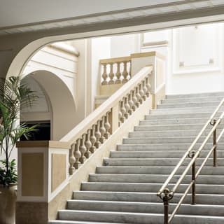 Marble steps paired with a stone column banister leading to a theatre foyer