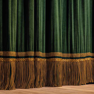 Gold fringing at the bottom of the green velvet stage curtains sweeps the boards of the Copacabana Palace Theatre