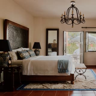 Casa Fuente's Deluxe Junior Suite combines history and elegance, with crisp bed linen, white walls, dark wood and antiques.