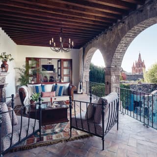 Luxurious hotel room terrace seating area with arched walls and stone floors