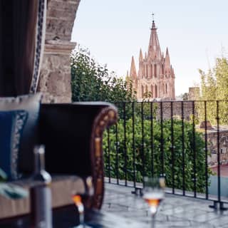 Vin rosé et verres sur une table basse extérieure avec vue sur San Miguel de Allende