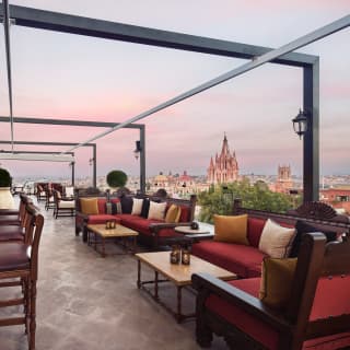 Evening falls at the lantern-lit rooftop bar, where sofas offer views across the rooftops of the old city