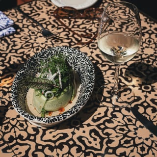 A dish of vibrant green huazontle and salt-cured nopal cactus ceviche is served with white wine at Restaurante del Parque.