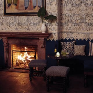 A blazing log fire in a period fireplace creates a cosy area inside Casa de Sierra Nevada’s Blue Bar