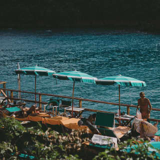 Turquoise parasols at harbourside tables overlooking the Ligurian sea