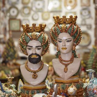 Two ornately painted ceramic busks among a selection of ceramic ornaments