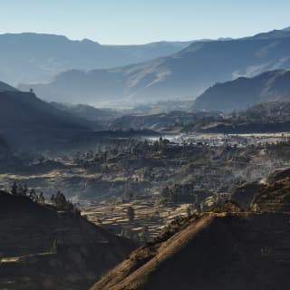 View of a verdant valley floor with mountains rising into the distance