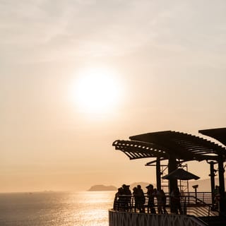 A shaded pier overlooking the Ballestas National Reserve at sunset