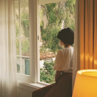 Woman looking at the garden from El Encanto hotel room