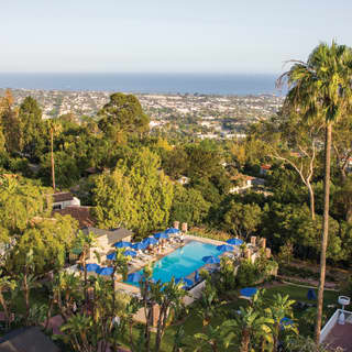 Aerial view of a hotel pool among lush gardens