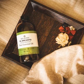 A bottle of El Encanto’s own pure citrus basil mint essential oil on a wooden tray in the hotel spa
