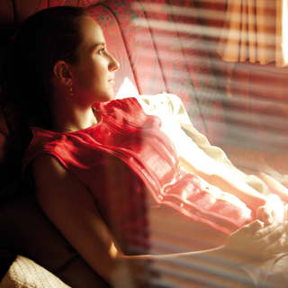Lady in a red top reclining in a train carriage
