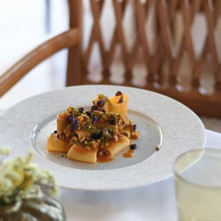 A dish of paccheri with flavourful squid ragoût, pine nuts, raisin and fennel-flavoured crumb, created at Ristorante Timeo.