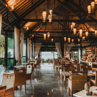 Clusters of lanterns glow above the tables and wicker chairs of Tunjung restaurant, with windows out to the sea and gardens.