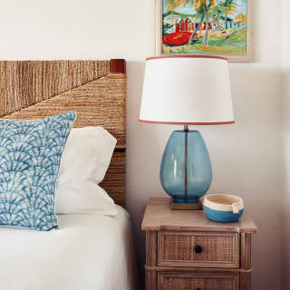 Blue cushion, bedside lamp and coin tray room details