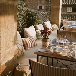 Rosy sun lights a corner of the terrace where tables and benches provide a luxurious spot to soak up the village ambience.