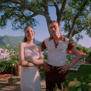 Influencer, Nara Smith and supermodel Lucky Blue Smith, stand at an outside table with bowls and crates of fresh lemons.