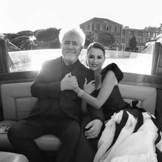 Black and white image of actress Penelope Cruz and film director, Pedro Almodóvar, dressed in style in a water taxi.