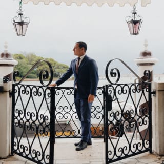 Andrea Zennaro, doorman at Hotel Cipriani, prepares to greet guests at the filigree gates under the hotel's entrance awning.