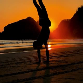 As the sun sets over Taormina's coast, Sam Youkilis captures a boy, silhouetted against the red sky, performing a handstand.