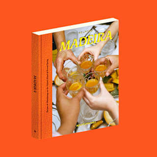 A book titled Madeira with a cover photo of several hands raising glasses in a toast, set against a bright orange background.