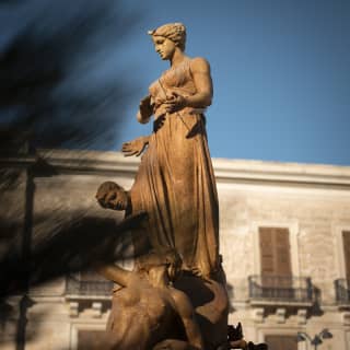 Sun glows on the fountain statue of Diana, also know as the fountain of Artemis, in Piazza Archimede in Syracuse.