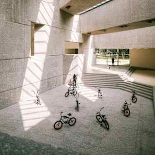Eight parked pushbikes feature in an art exhibition in a concrete hall with skylights at the Museo Tamayo Arte Contemporáneo.