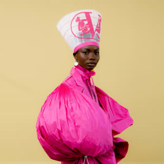 Model Marie Kone wears an electric pink Valentino haute couture dress repurposed as a puff-sleeve coat by Thebe Magugu.