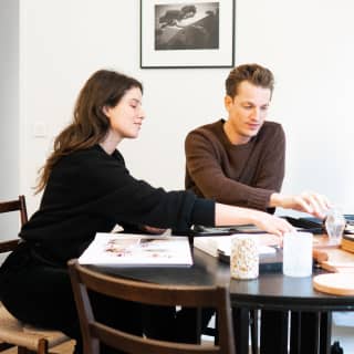 Male and female interior designer at a table comparing designs