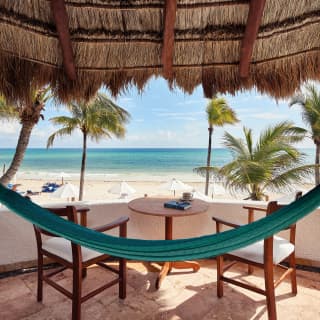 Blue hammock stretched across a terrace, overlooking the Riviera Maya