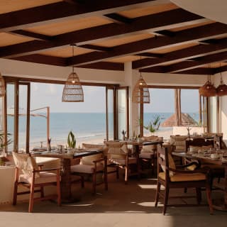 Window tables bathe in wide exterior sea-views and the interior elegance of Casa Mayor's calming, white and wicker décor.