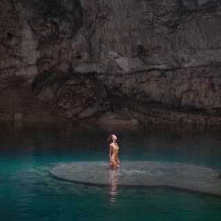 woman standing inside of a cenote