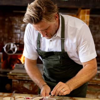 Chef Curtis Stone spoons spices from ramekins in a careful preparation of Beef Tartare on the marble counter at  Woodend.