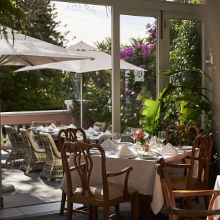 Inside dining meets al-fresco seating with  lounge doors that open out onto the terrace, with a flow of neatly-laid tables.