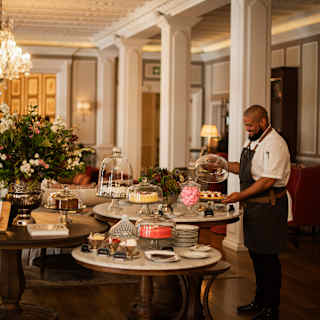 Chef Matthew Paulsen unveils his sweet creations at an Afternoon Tea table filled with cakes and sweet treats in the lounge.