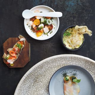 Birds-eye-view of a selection of delicious dishes served on a black slate table