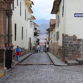 Cobbled streets and old stone houses in historic Cusco with views to the mountains beyond