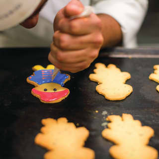 A chef decorates colourful children’s biscuits in this family friendly hotel